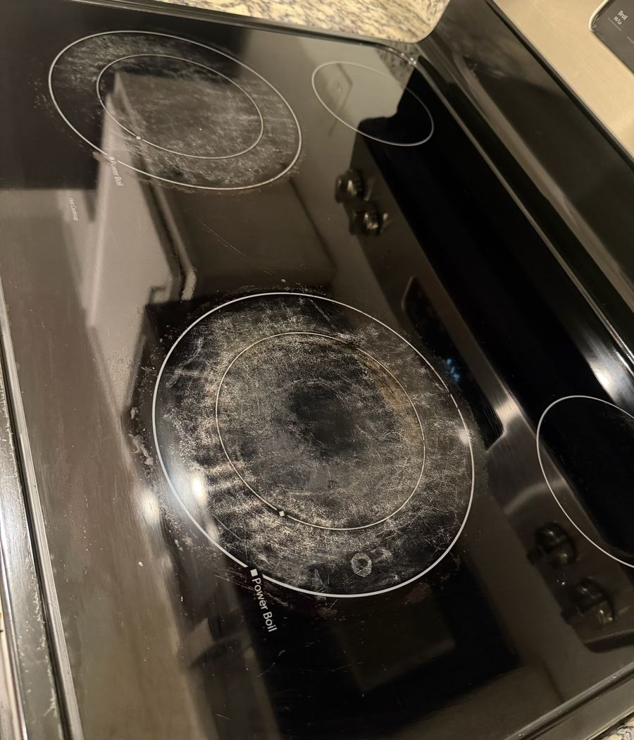 Glass cooktop burners hazy with burnt-on residue before cleaning
