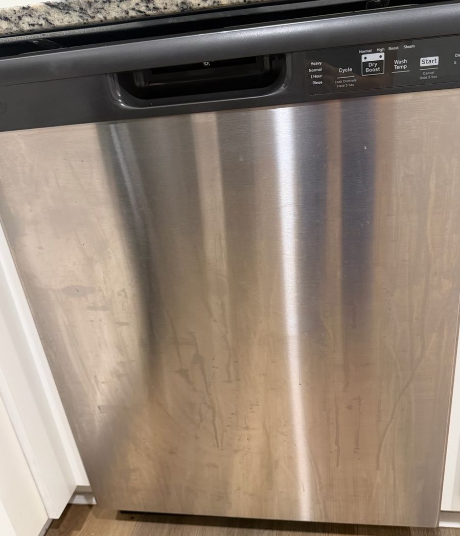 Dishwasher front covered in drip streaks and smudges before cleaning